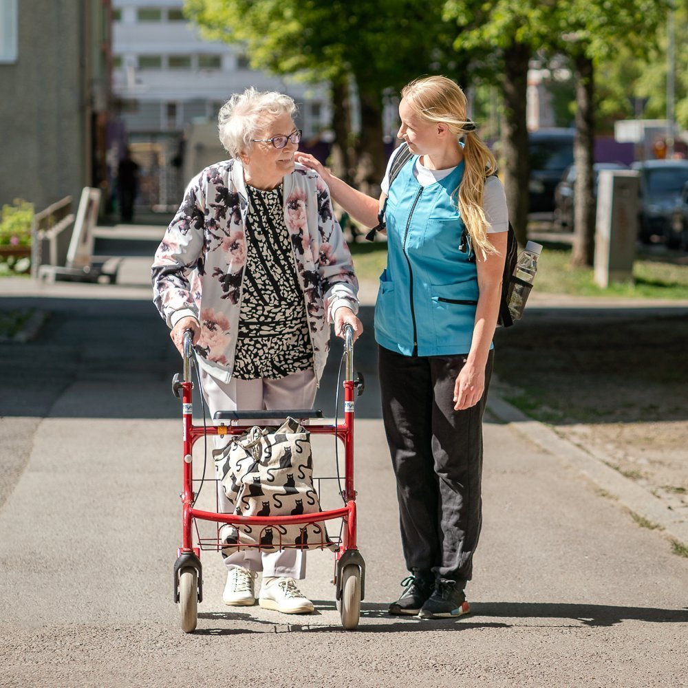 Ikäihminen ja hoitaja keskustelevat ulkona