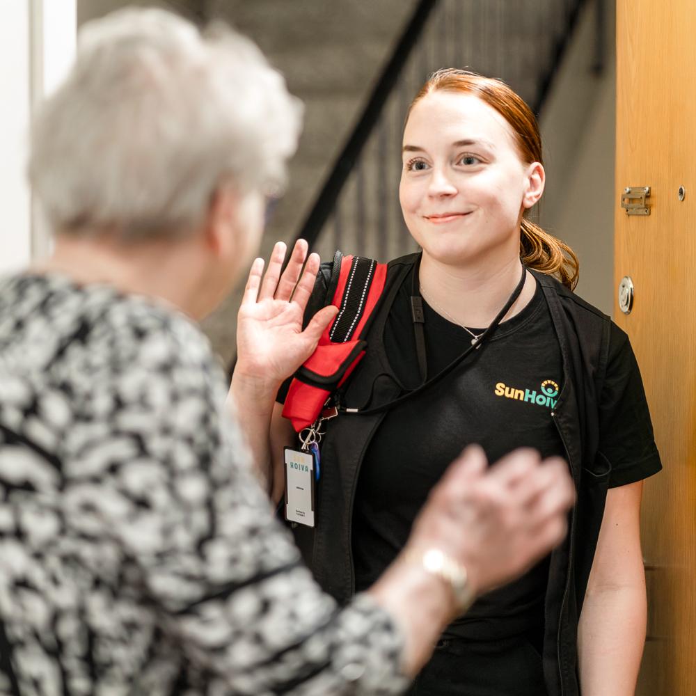 Hoitaja tervehtii kotihoidon asiakasta