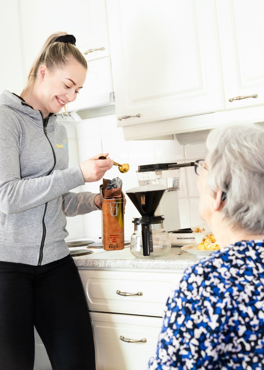 SunHoivan hoitaja keittää kahvia ikäihmisen kanssa